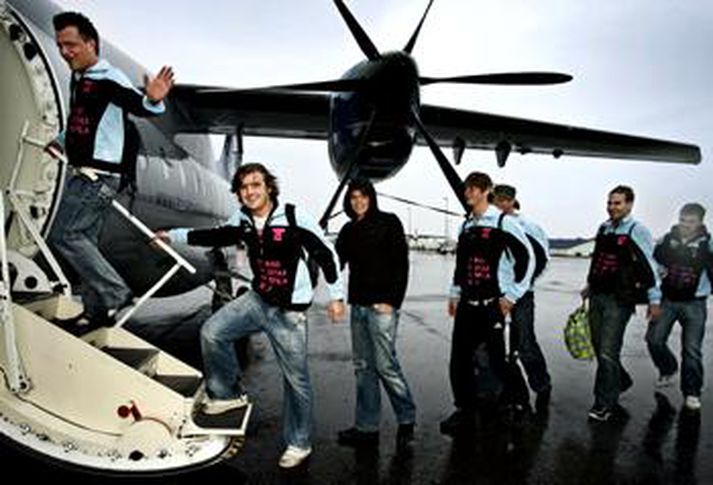 Ánægðir flugfarþegar á leið upp í flugvél.