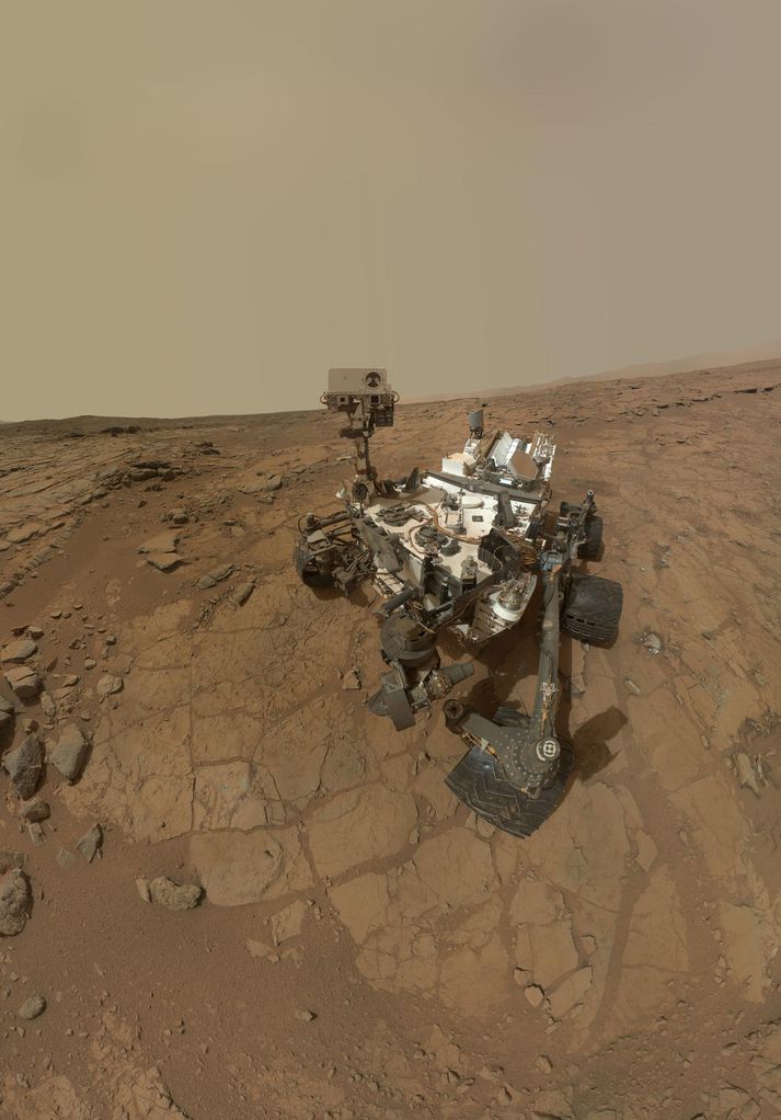 Sjálfsmynd sem Curiosity tók á John Klein svæðinu þar sem hann undirbjó fyrstu borunina á annarri reikistjörnu. Sjá má merki um fyrstu prófanir borsins neðarlega vinstra megin. Á þessum stað hefur Curiosity fundið sönnunargögn þess efnis að Mars hafi eitt sinn líkega verið lífvænlegur.