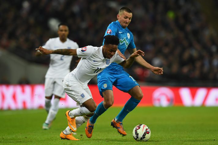 Milivoje Novakovic er aðstoðarþjálfari slóvenska landsliðsins. Hann lék áttatíu leiki fyrir það á sínum tíma. Hér sést hann í baráttu við Raheem Sterling í leik gegn Englands í undankeppni EM í nóvember 2014.