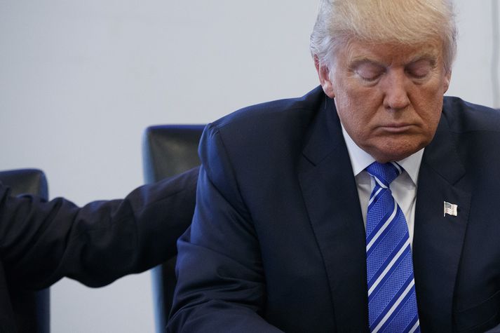 Donald Trump fær hér klapp á bakið frá ráðgjafa sínum á fundi í Trump Tower í gær.