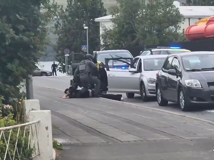 Erfitt er að sjá hve margir mennirnir á gangstéttinni eru á myndskeiðinu.