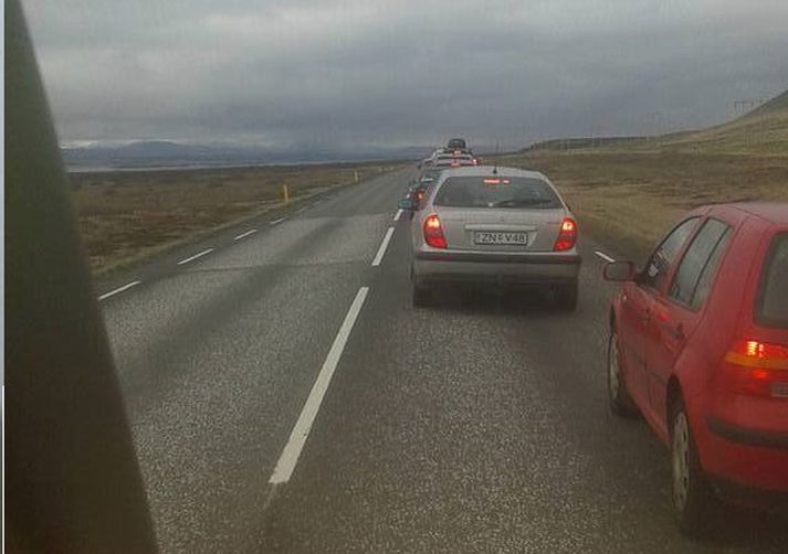 Bílar bíða í langri röð við Hafnarfjall.