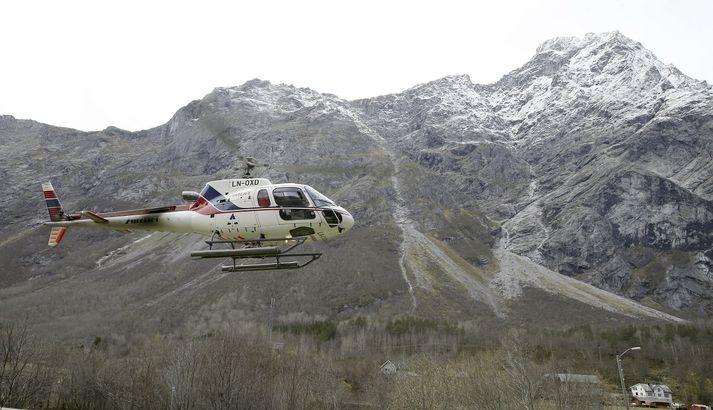 Þyrla á flugi við Mannen árið 2014. Þá var einnig skriðuhætta í fjallinu.