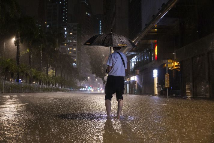 Vegfarandi veður elginn í Hong Kong í morgun.