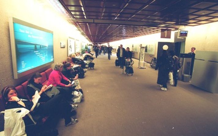 Fólk bíður við brottfararsal í Leifsstöð. Ósagt skal látið hvort eitthvert þeirra hefur flutt úr landi.