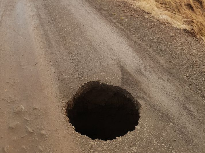 Holan er stór og gæti valdið miklum skemmdum á bíl sem ekið yrði þarna ofan í.