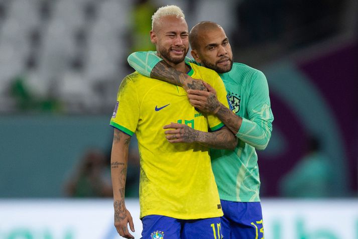Dani Alves huggar Neymar eftir að Brasilíumenn duttu út í átta liða úrslitum á HM í Katar 2022.