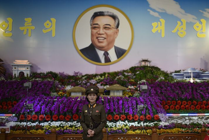 Hermaður stendur fyrir framan mynd af Kim Il Sung, afa Kim Jong-un.