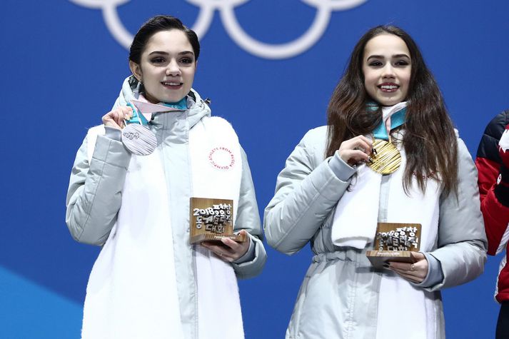 Rússarnir Evgenia Medvedeva og Alina Zagitova með verðlaun sín og með nú "fræga“ trefilinn um hálsinn.