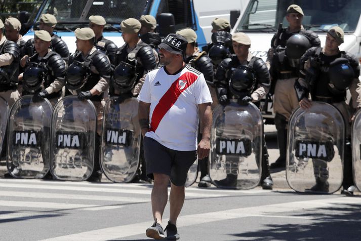 Stuðningsmaður River Plate fyrir framan óeirðalögregluna í Buenos Aires.