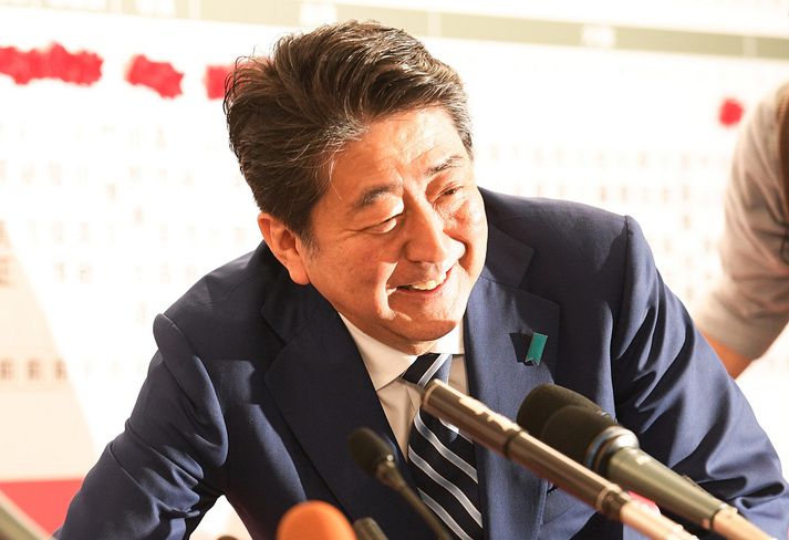 Shinzo Abe, forsætisráðherra Japans, mun að öllum líkindum endurnýja umboð sitt í nýafstöðnum kosningum. Hann ræðir hér við blaðamenn eftir að kjörstaðir lokuðu klukkan 20 að japönskum tíma í dag.