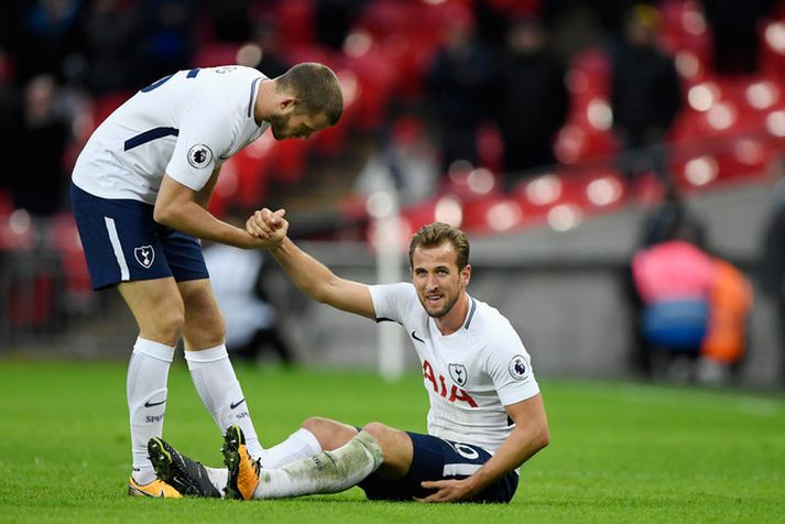 Eric Dier hjálpar Harry Kane á fætur.