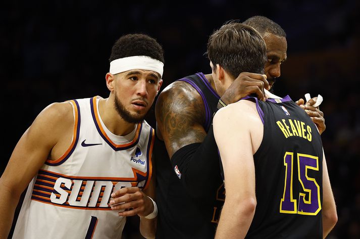 LeBron og Reaves ræða málin á meðan Devin Booker reynir að heyra hvað fer þeirra á milli.