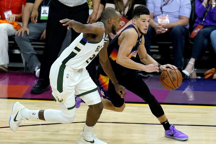 Devin Booker átti mjög flottan leik í nótt og hér fer hann framhjá Khris Middleton.