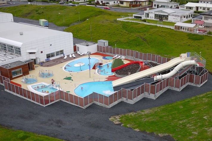 Leiklaugin er hægra megin við vaðlaug efst á myndinni. Laugarnar eru aðskildar með rauðri brú.