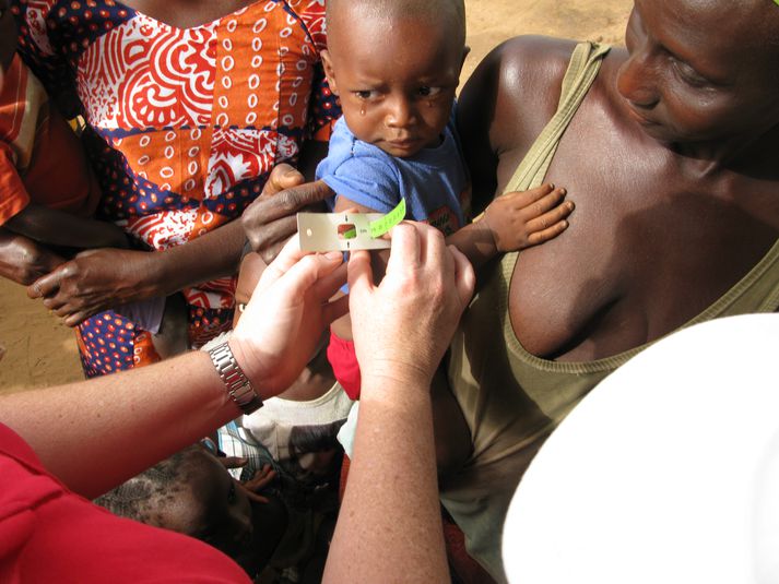 Starfsfólk Rauða krossins mælir vannæringu hjá ungu barni.
