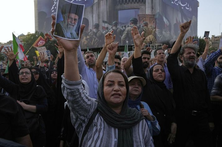 Íranir hópast saman á götum höfuðborgarinnar og mótmæla árásum Bandaríkjahers. Einn mótmælandi heldur uppi mynd af Ayatollah Ali Khamenei æðsta leiðtoga Íran.