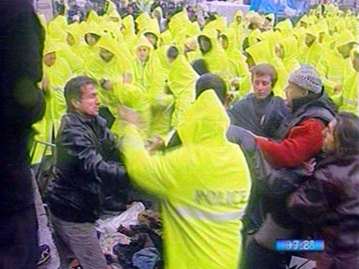 Lögreglumenn reyna að leysa upp mótmæli stjórnarandstæðinga fyrir framan þinghúsið í Tblisi.