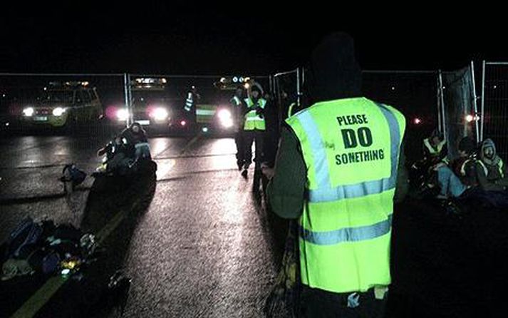 Mótmælendurnir klæðast skærgrænum vestum með áletruninni „Gerðu eitthvað“ sem vísar til umhverfisverndarsjónarmiða þeirra.
