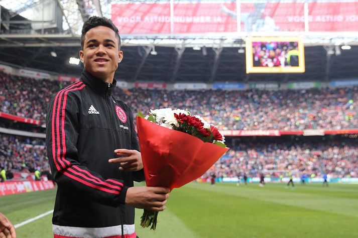Justin Kluivert fær hér blóm eftir undirskriftina í gær.