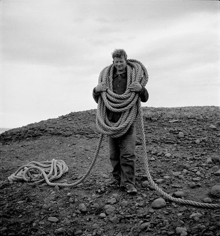 Eiríkur Sigmundsson, bóndi í Fagranesi á Reykjaströnd, við bjargsig í Drangey með uppgjörðan vað á öxlum. 1938.