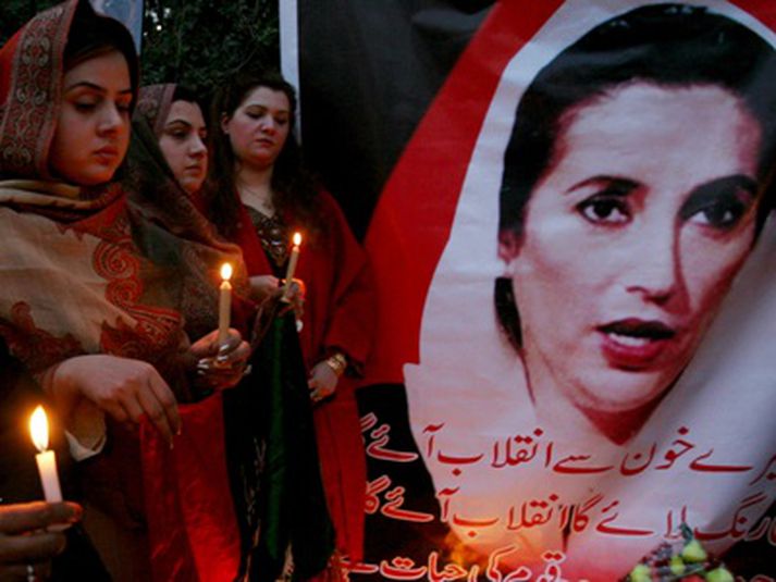 Syrgjendur við plakat af Benazir Bhutto.