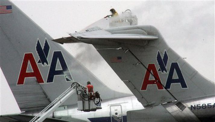 Starfsmenn flugfélagsins American Airlines reyna að koma í veg fyrir ísingu á flugvélum félagsins á Dallas-flugvelli í gær.
