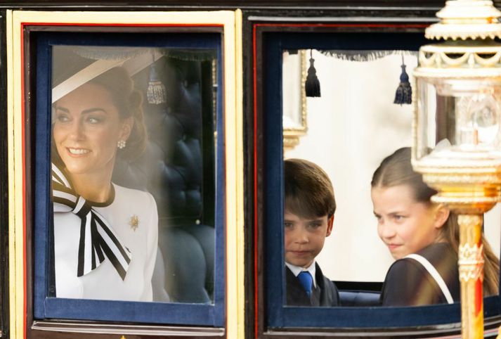 Katrín ásamt börnum sínum, Lúðvík prins og Karlottu prinsessu, í hestvagni í skrúðgöngunni í dag. 
