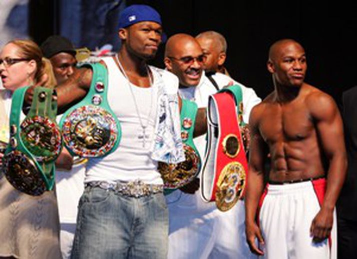 Mayweather (til hægri) var með vígalegt föruneyti í vigtuninni og hér má sjá rapparann 50 cent halda á meistarabeltum kappans