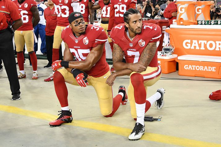 Colin Kaepernick og Eric Reid, liðsfélagi hans, mótmæla á meðan þjóðsöngurinn er spilaður.