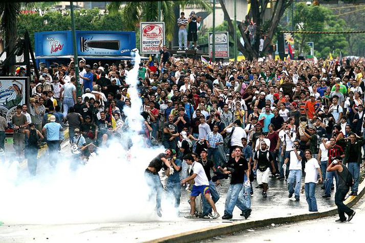 Mótmæli í Caracas. Háskólanemar köstuðu táragassprengju frá lögreglunni aftur til baka á mótmælafundi í Caracas á þriðjudag.