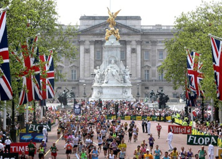 Keppendur koma í mark við Buckingham höll í London maraþoninu.