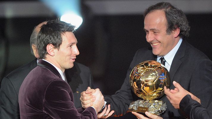 Lionel Messi fær hér Gullboltann frá Michel Platini í gær.