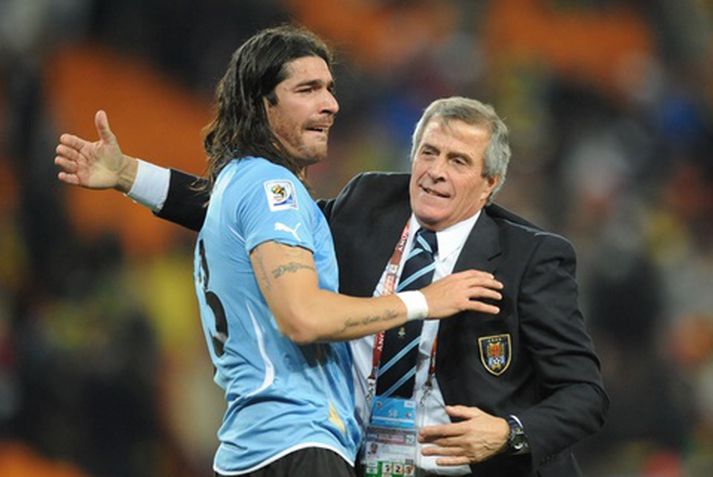 Vítaskyttan ískalda Sebastian Abreu fagnar með landsliðsþjálfaranum Oscar Tabarez eftir leikinn í gær.