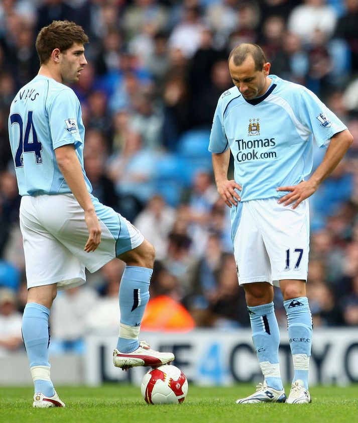 Martin Petrov og Ched Evans horfa niðurlútir á leikmenn Fulham fagna marki.