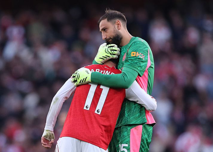 Gianluigi Donnarumma faðmar Gabriel Martinelli sem tryggði Arsenal stig gegn Manchester City í gær.