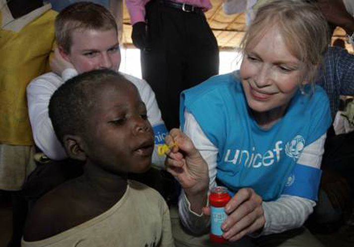 Leikkonan Mia Farrow, sem er góðgerðarsendiherra Unicef, aðstoðar hér barn við að blása sápukúlur. Mynd/ AFP.