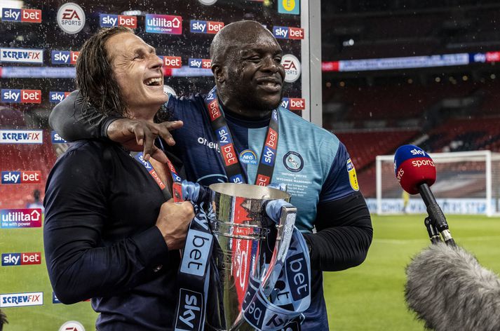 Adebayo Akinfenwa og Gareth Ainsworth, knattspyrnustjóri Wycombe Wanderers, eftir sigurinn á Oxford United í gær.