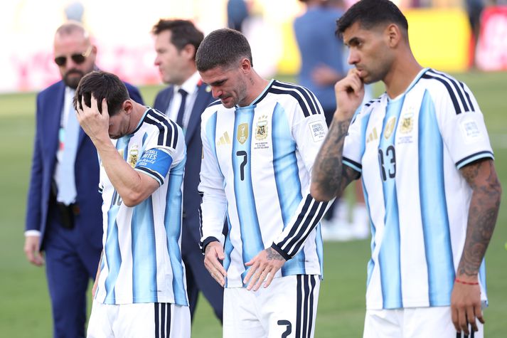 Rodrigo de Paul sést hér niðurbrotinn við hlið Lionel Messi eftir að ljóst var að argentínska landsliðið hafði tapað úrslitaleiknum og möguleikanum á því að verja titilinn.