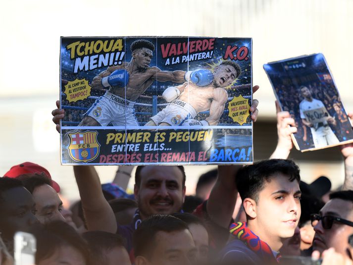 Stuðningsmenn Barcelona halda uppi grínmynd af Aurelien Tchouameni að kýla Federico Valverde, liðsfélaga sinn hjá Real Madrid.