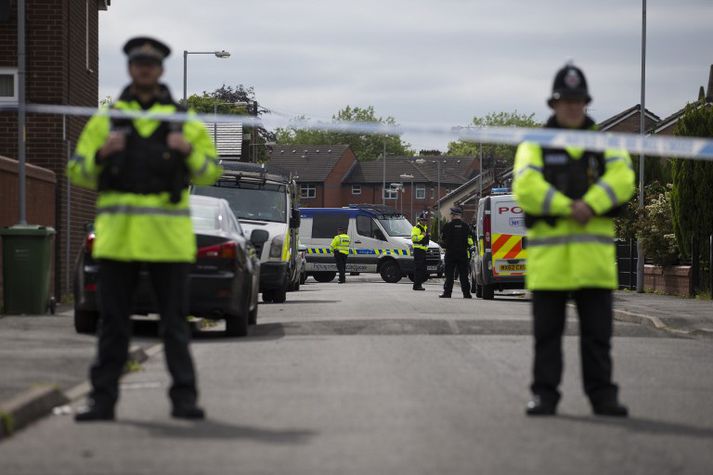 Lögregla girti af götur í Moss Side í Manchester í dag.