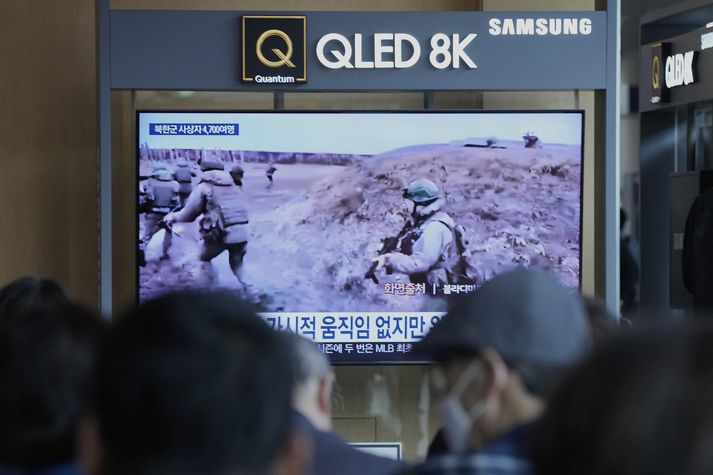 Fólk í Seoul í Suður-Kóreu horfir á myndband af norðurkóreskum hermönnum við æfingar í Rússlandi.