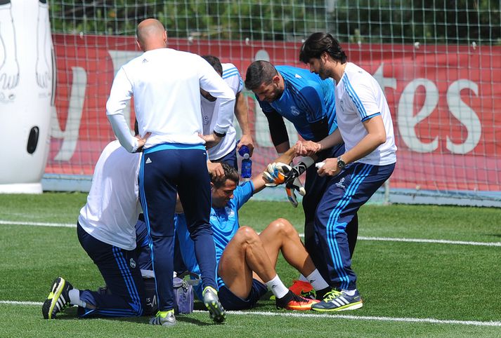 Cristiano Ronaldo fær hér hjálp við að standa á fætur.