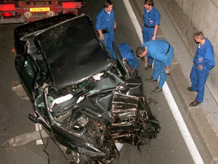 Björgunarmenn að störfum við Mercedes Benz bifreiðina í göngunum eftir slysið.