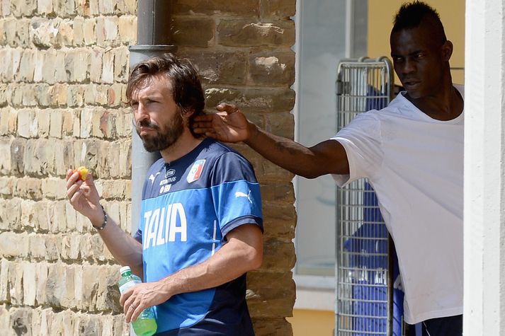 Andstæður. Mario Balotelli, skemmtikraftur hrekkir hér Andrea Pirlo.