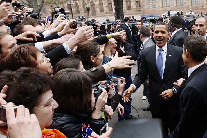 Fólk sem hleypt var nærri leiðtogunum reynir að heilsa Barack Obama Bandaríkjaforseta fyrir utan fundarstaðinn í Strassborg í gær.  fréttablaðið/AP
