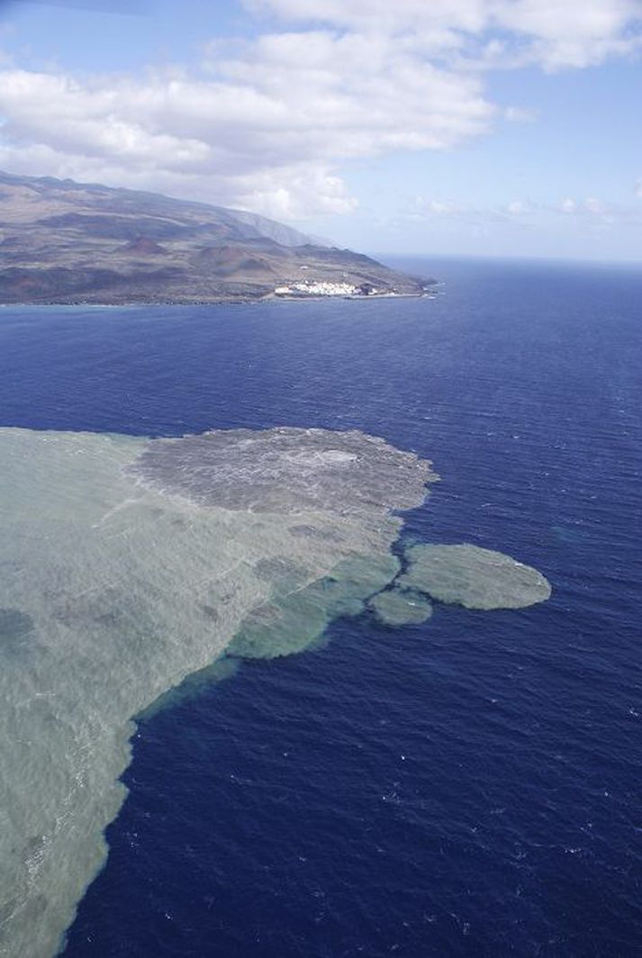 Gríðarstór öskuflekkur liggur á haffletinum úti af El Hierro. Bærinn La Restinga er í stuttri fjarlægð frá gosstöðvunum.
