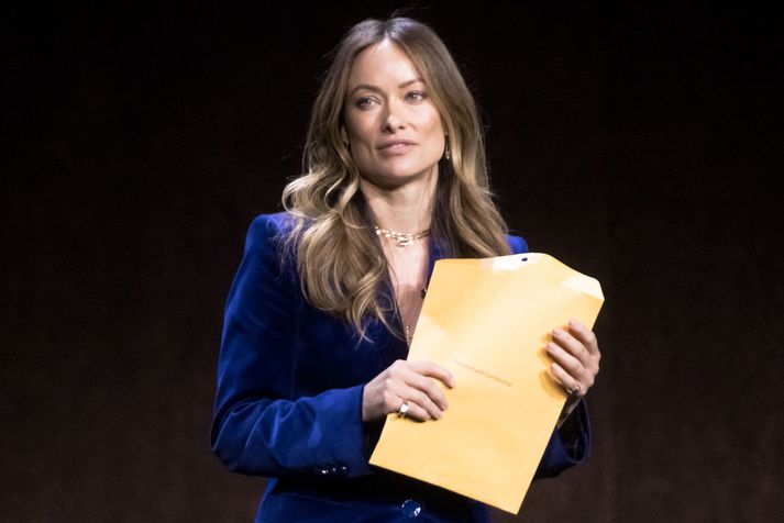 Olivia Wilde var stödd á sviðinu þegar kona kom og rétti henni umslagið með stefnunni.