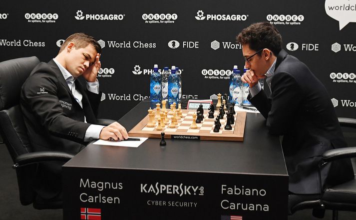 Carlsen og Caruana í níundu einvígisskákinni. Takið eftir plástrinum á hægri augabrún heimsmeistarans en hann kom til eftir skallaeinvígi.