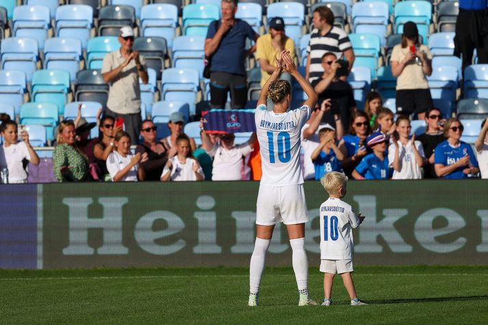 Dagný Brynjarsdóttir og sonur hennar klappa fyrir áhorfendum á Evrópumótinu í Englandi síðasta sumar.